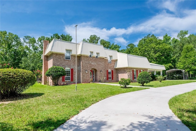 174 SW Dalmation Ln, Lake City, FL 32024 - view of front of house featuring a chimney, a front lawn, a metal roof, and brick siding