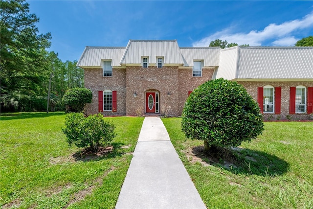 174 SW Dalmation Ln, Lake City, FL 32024 - view of front of property with a front yard, brick siding, and a metal roof