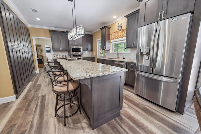 174 SW Dalmation Ln, Lake City, FL 32024 - kitchen with appliances with stainless steel finishes, crown molding, light stone countertops, light wood-style flooring, and tasteful backsplash