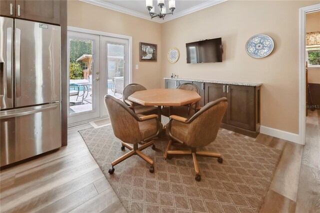 174 SW Dalmation Ln, Lake City, FL 32024 - dining area featuring crown molding, light wood-style flooring, french doors, and a chandelier