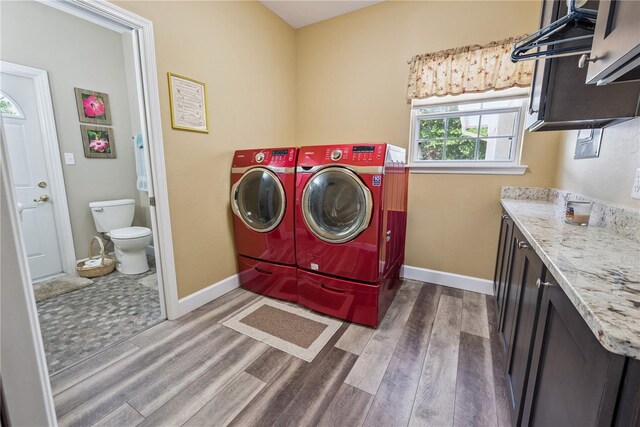 174 SW Dalmation Ln, Lake City, FL 32024 - laundry area featuring cabinet space, washing machine and dryer, and wood finished floors