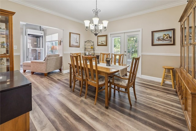 174 SW Dalmation Ln, Lake City, FL 32024 - dining space with dark wood finished floors, ornamental molding, a chandelier, and french doors