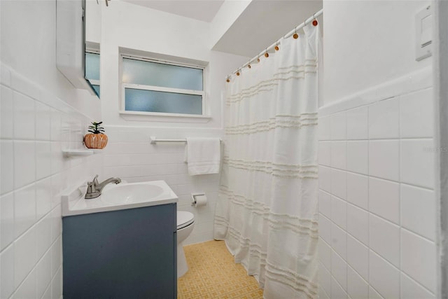 1604 NE 7th St, Gainesville, FL 32609 - full bath featuring tile walls, vanity, tile patterned floors, a shower with shower curtain, and a wainscoted wall