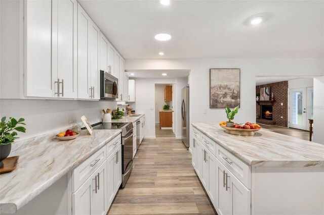 1604 NE 7th St, Gainesville, FL 32609 - kitchen featuring appliances with stainless steel finishes, light wood-type flooring, white cabinetry, and recessed lighting