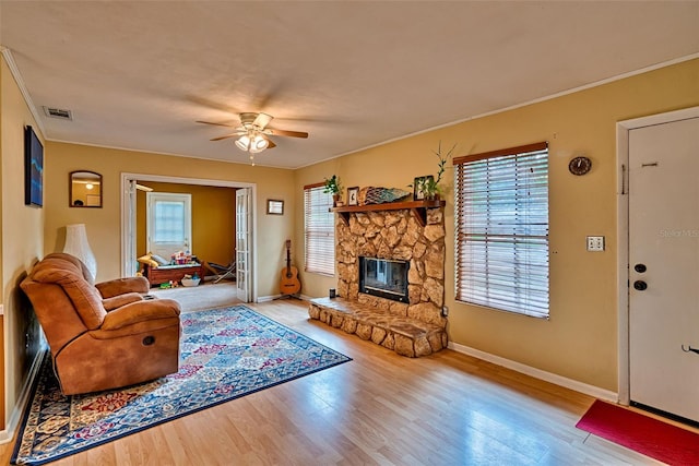 2510 NW 50th Pl, Gainesville, FL 32605 - living area featuring a ceiling fan, wood finished floors, a stone fireplace, and ornamental molding
