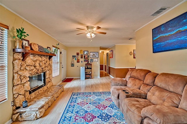 2510 NW 50th Pl, Gainesville, FL 32605 - living area featuring ceiling fan, light wood-type flooring, ornamental molding, and a stone fireplace