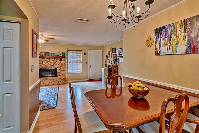2510 NW 50th Pl, Gainesville, FL 32605 - dining area featuring crown molding, light wood-style flooring, a chandelier, ceiling fan, and a fireplace
