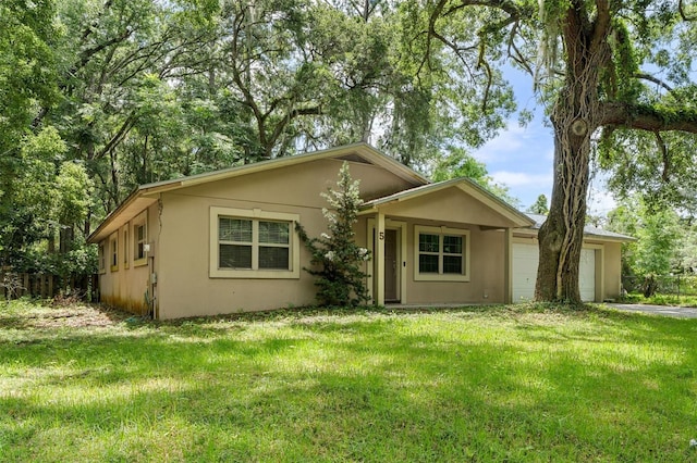 5 NW 28th Ter, Gainesville, FL 32607 - view of front of home featuring stucco siding, an attached garage, and a front yard
