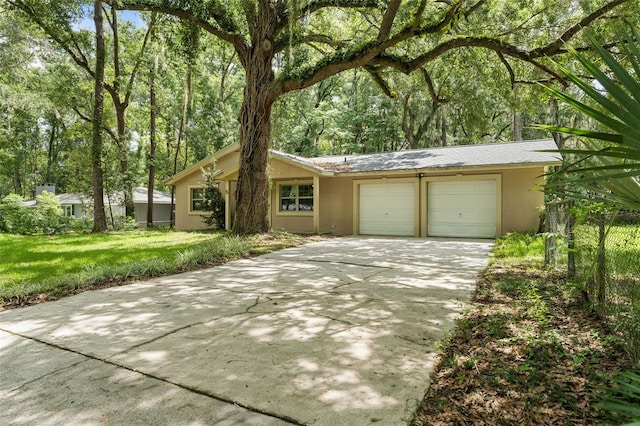 5 NW 28th Ter, Gainesville, FL 32607 - ranch-style house with stucco siding, an attached garage, and driveway