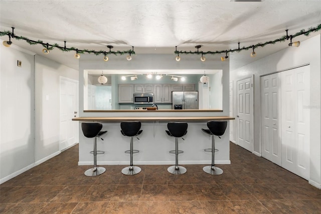 5 NW 28th Ter, Gainesville, FL 32607 - kitchen with stainless steel appliances, a kitchen breakfast bar, rail lighting, and pendant lighting