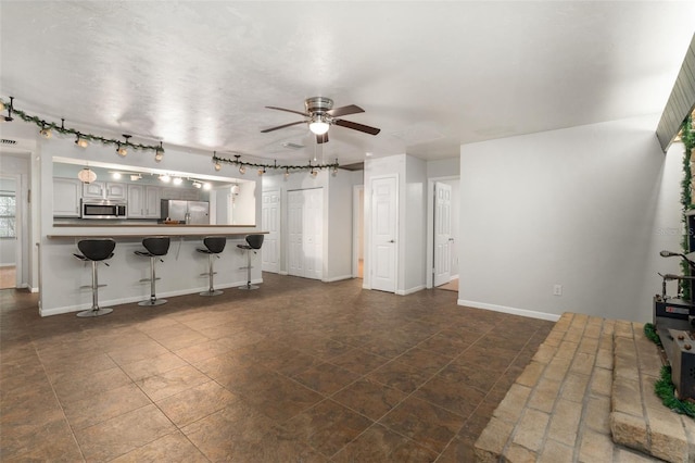 5 NW 28th Ter, Gainesville, FL 32607 - unfurnished living room featuring a ceiling fan and track lighting