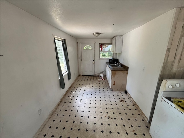 654 NE 2nd St, Crystal River, FL 34429 - kitchen featuring range, light flooring, dark countertops, and white cabinetry