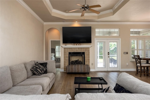 3737 SW 74th Dr, Gainesville, FL 32608 - living area featuring a tray ceiling, wood finished floors, ceiling fan, crown molding, and arched walkways