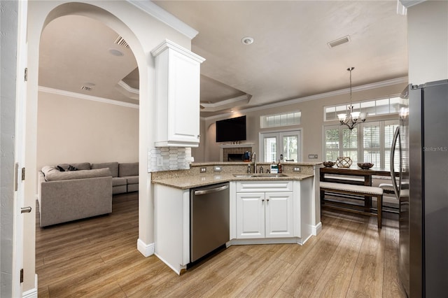 3737 SW 74th Dr, Gainesville, FL 32608 - kitchen featuring stainless steel appliances, open floor plan, light wood finished floors, white cabinets, and crown molding