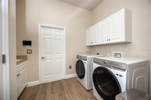 3737 SW 74th Dr, Gainesville, FL 32608 - laundry area with cabinet space, separate washer and dryer, and light wood-style flooring
