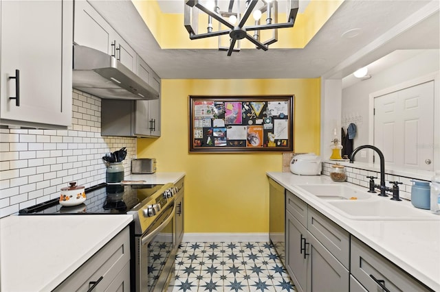900 SW 62nd Blvd Unit H43, Gainesville, FL 32607 - kitchen featuring electric stove, under cabinet range hood, gray cabinetry, light flooring, and tasteful backsplash