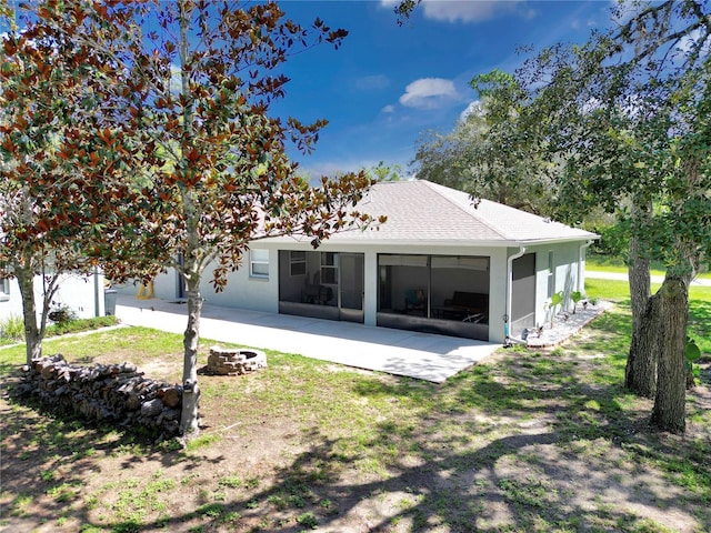 8198 N Brook Way, Citrus Springs, FL 34433 - back of house featuring a patio area, a sunroom, stucco siding, a shingled roof, and a fire pit