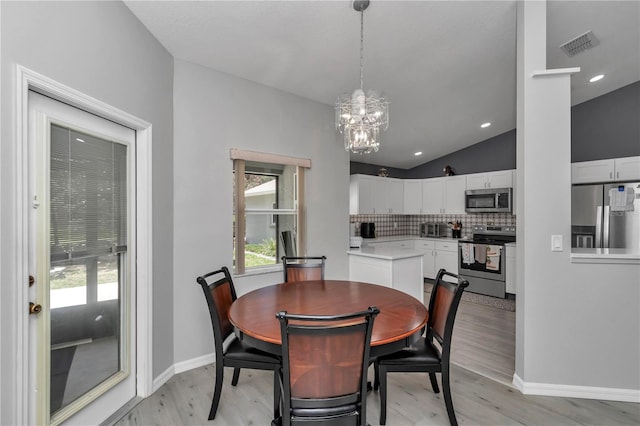 8198 N Brook Way, Citrus Springs, FL 34433 - dining area featuring lofted ceiling, a chandelier, and light wood-type flooring