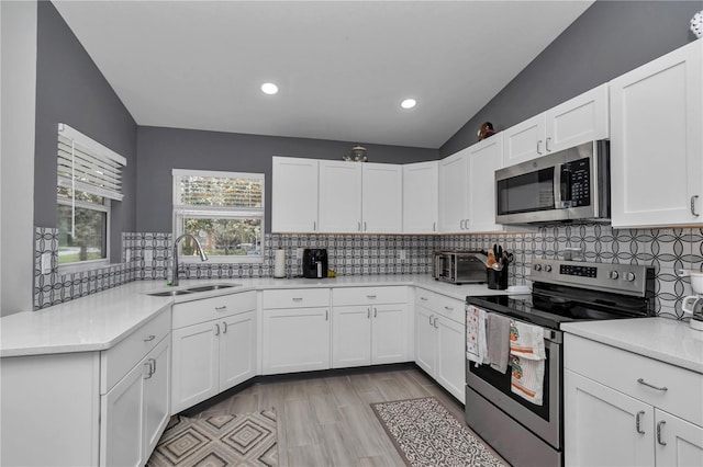 8198 N Brook Way, Citrus Springs, FL 34433 - kitchen featuring appliances with stainless steel finishes, light countertops, white cabinetry, tasteful backsplash, and recessed lighting