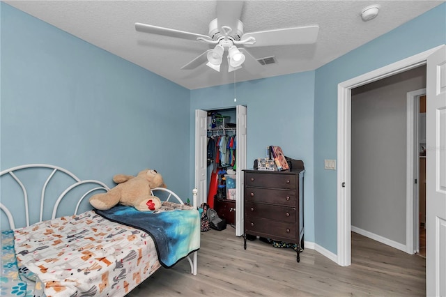 8198 N Brook Way, Citrus Springs, FL 34433 - bedroom featuring wood finished floors, a closet, a textured ceiling, and ceiling fan