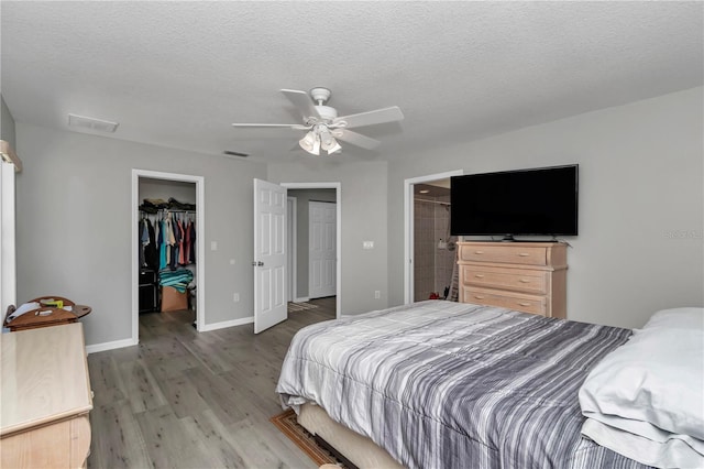 8198 N Brook Way, Citrus Springs, FL 34433 - bedroom with a spacious closet, wood finished floors, a ceiling fan, a closet, and a textured ceiling