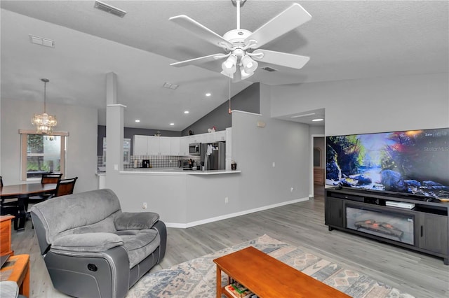 8198 N Brook Way, Citrus Springs, FL 34433 - living room with vaulted ceiling, light wood-style floors, a ceiling fan, a chandelier, and recessed lighting