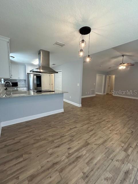 3372 Penny Ln, Middleburg, FL 32068 - kitchen featuring extractor fan, refrigerator, dark wood-style floors, open floor plan, and a peninsula