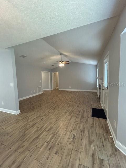 3372 Penny Ln, Middleburg, FL 32068 - unfurnished living room featuring wood finished floors, lofted ceiling, ceiling fan, and a textured ceiling