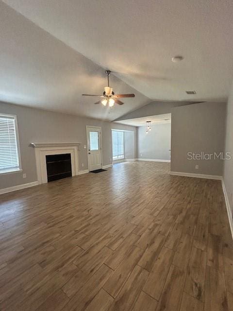 3372 Penny Ln, Middleburg, FL 32068 - unfurnished living room with dark wood finished floors, vaulted ceiling, a fireplace, and ceiling fan