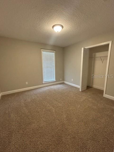 3372 Penny Ln, Middleburg, FL 32068 - unfurnished bedroom featuring a textured ceiling, carpet, and a closet