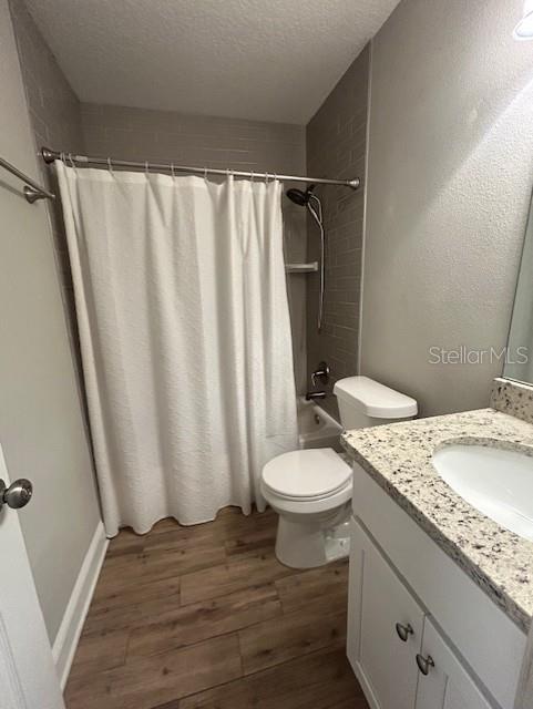 3372 Penny Ln, Middleburg, FL 32068 - bathroom with vanity, a textured ceiling, wood finished floors, and shower / tub combo with curtain