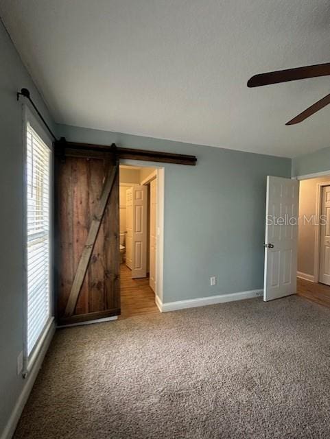 3372 Penny Ln, Middleburg, FL 32068 - unfurnished bedroom featuring light carpet, a barn door, and ceiling fan