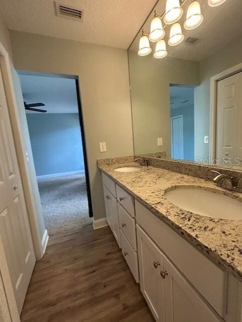3372 Penny Ln, Middleburg, FL 32068 - bathroom featuring double vanity, wood finished floors, a textured ceiling, and a ceiling fan