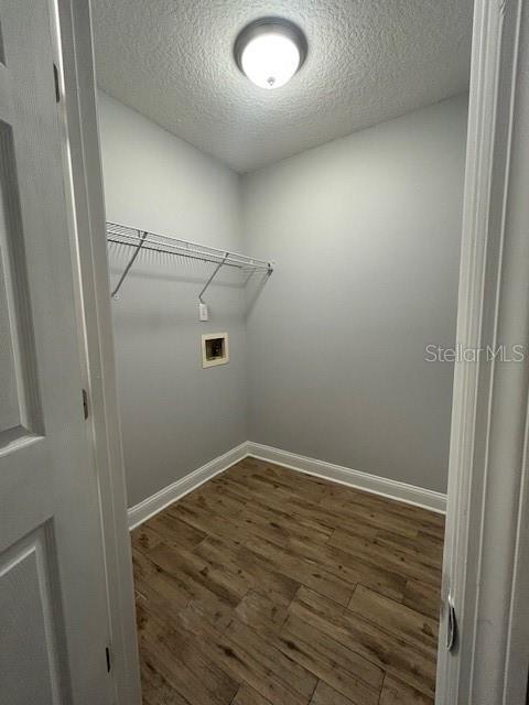 3372 Penny Ln, Middleburg, FL 32068 - laundry area featuring washer hookup, a textured ceiling, and dark wood-style flooring