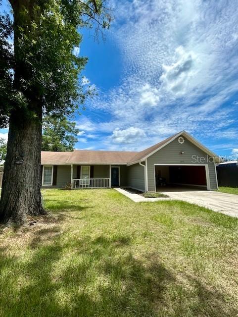 3372 Penny Ln, Middleburg, FL 32068 - ranch-style home featuring a garage, driveway, a front yard, and a porch
