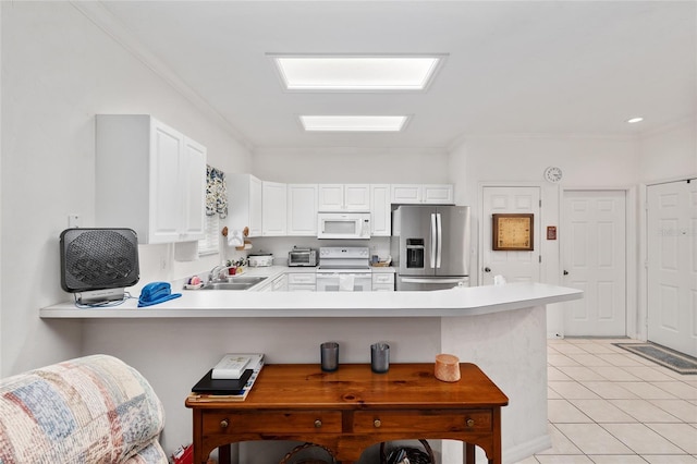 4814 NW 75th Rd, Gainesville, FL 32653 - kitchen with white appliances, a peninsula, a kitchen breakfast bar, light countertops, and ornamental molding