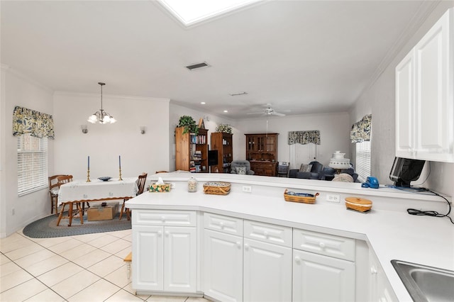 4814 NW 75th Rd, Gainesville, FL 32653 - kitchen featuring a peninsula, light countertops, white cabinetry, a chandelier, and ornamental molding