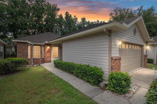 4814 NW 75th Rd, Gainesville, FL 32653 - single story home featuring brick siding, a garage, driveway, a front yard, and a shingled roof