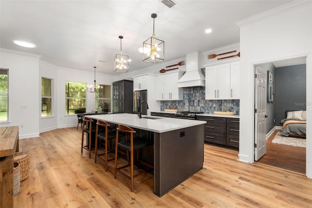 6326 SW 90th St, Gainesville, FL 32608 - kitchen featuring custom range hood, a chandelier, a large island with sink, healthy amount of natural light, and crown molding