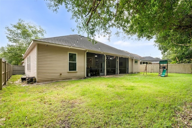 6326 SW 90th St, Gainesville, FL 32608 - back of house with a playground, a sunroom, a fenced backyard, and roof with shingles