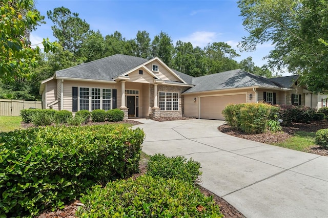 6326 SW 90th St, Gainesville, FL 32608 - view of front of property with an attached garage, driveway, roof with shingles, and stone siding