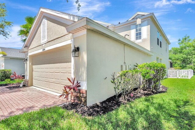 6364 Golden Eye Gln, Lakewood Ranch, FL 34202 - view of home's exterior with an attached garage, stucco siding, and decorative driveway