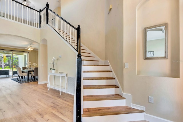6364 Golden Eye Gln, Lakewood Ranch, FL 34202 - stairway with arched walkways, ceiling fan, a high ceiling, and wood finished floors