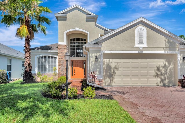 6364 Golden Eye Gln, Lakewood Ranch, FL 34202 - view of front of house with decorative driveway, a front yard, a garage, and stucco siding