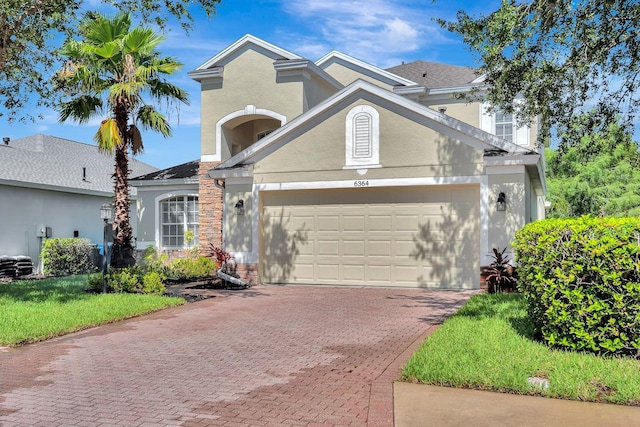 6364 Golden Eye Gln, Lakewood Ranch, FL 34202 - traditional home with decorative driveway, an attached garage, and stucco siding