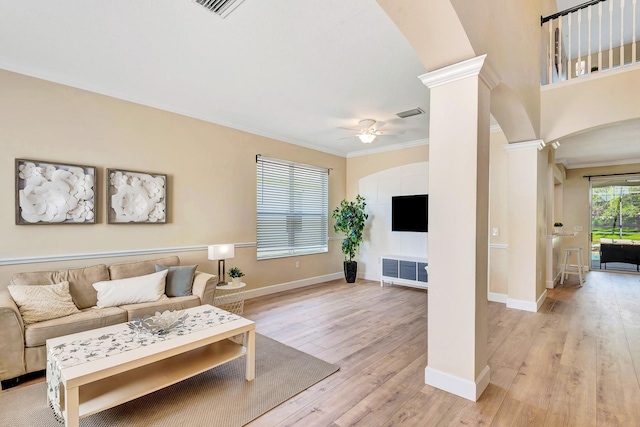 6364 Golden Eye Gln, Lakewood Ranch, FL 34202 - living room featuring ornate columns, ceiling fan, crown molding, arched walkways, and light wood-type flooring
