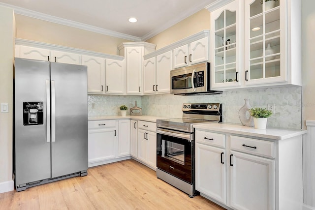 6364 Golden Eye Gln, Lakewood Ranch, FL 34202 - kitchen with appliances with stainless steel finishes, glass insert cabinets, white cabinets, crown molding, and light countertops