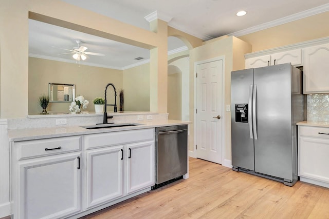 6364 Golden Eye Gln, Lakewood Ranch, FL 34202 - kitchen featuring stainless steel appliances, ornamental molding, white cabinets, a ceiling fan, and light wood-type flooring