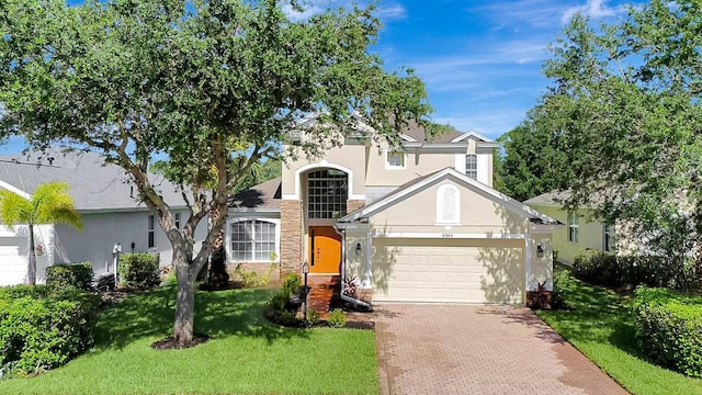 6364 Golden Eye Gln, Lakewood Ranch, FL 34202 - traditional-style house with stucco siding, a garage, decorative driveway, a front yard, and stone siding
