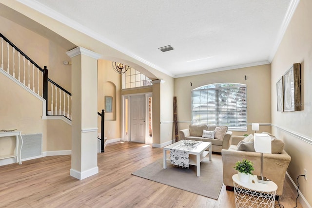 6364 Golden Eye Gln, Lakewood Ranch, FL 34202 - living area with stairway, wood finished floors, crown molding, and arched walkways